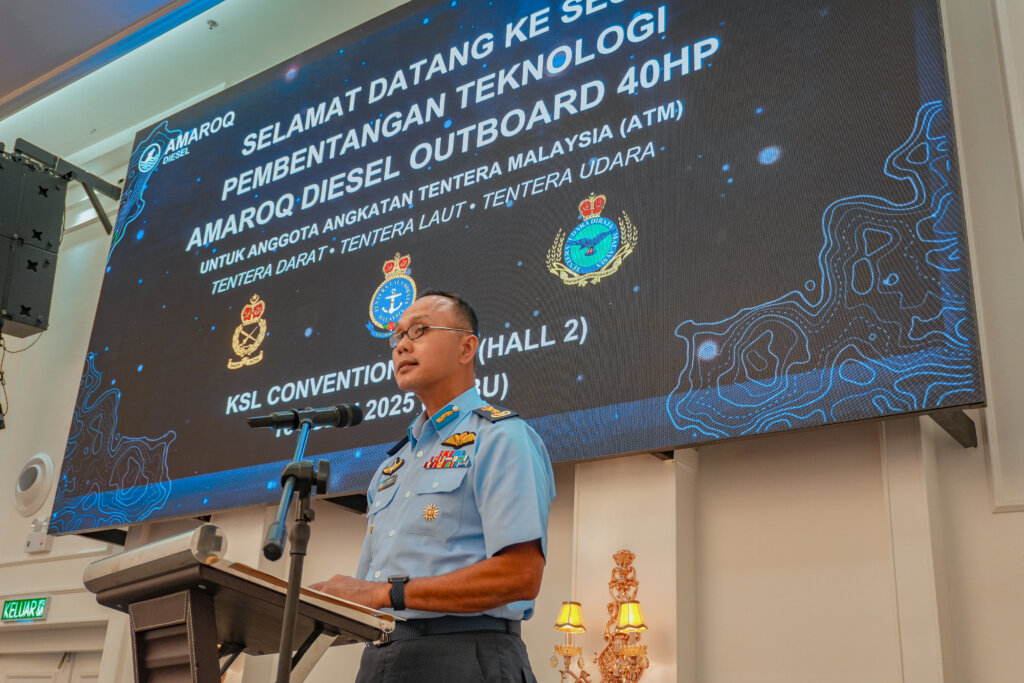 Malaysian Armed Forces officer in light blue uniform delivering a speech at a podium during the AMAROQ Diesel Outboard 40HP Technology Presentation, held at KSL Convention Centre. A large digital screen in the background displays event details and military insignias for the Army, Navy, and Air Force.